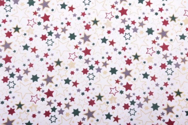 Vianočná látka z bavlny v jemnom odtieni smotanovej farby s potlačou farebných hviezdič 12714/051